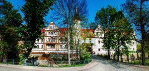 SchkopauHotel Schloss Schkopau的前面有树木的白色大建筑