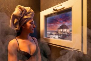佛罗伦萨贝拉维斯塔酒店的电视旁的女人头上戴着毛巾