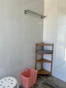 加的斯BOHO GLAMPING CONIL的浴室设有粉红色的篮子和架子