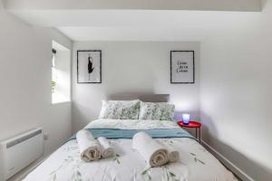 卢顿Luton Cozy & Lovely Stay for Contractors的白色卧室,配有带毛巾的床
