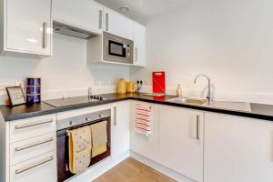 卢顿Luton Cozy & Lovely Stay for Contractors的厨房配有白色橱柜和水槽