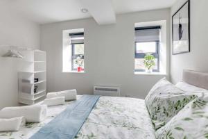 卢顿Luton Cozy & Lovely Stay for Contractors的白色卧室设有一张大床和两个窗户