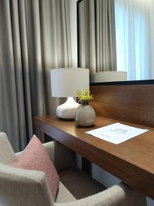 哈尔基多纳梅森酒店的一张桌子,位于酒店的房间,配有灯和椅子
