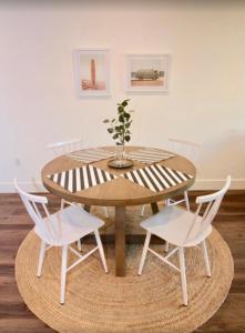 什切青Black Pearl Apartments in Old Town的一张木桌,上面有两把白色的椅子和花瓶