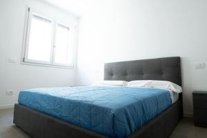 蒙扎[Da Lorenzo] - between station and center的一间卧室配有一张带蓝色毯子的大床