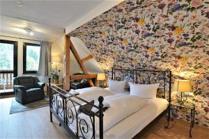 布罗特罗德Pension Pfefferstübchen的一间卧室配有一张带花卉墙壁的床
