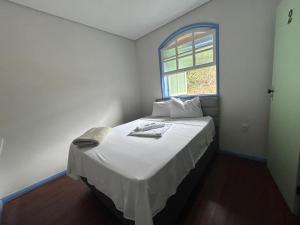 欧鲁普雷图Ouro Preto Suítes的一间小卧室,配有一张白色的床和窗户