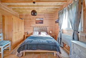 圣吉隆Maisonnette à la campagne Ariège的小木屋内一间卧室,配有一张床
