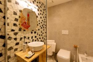 奥尔比亚CasAunoE Boutique Hotel的一间带水槽、卫生间和镜子的浴室