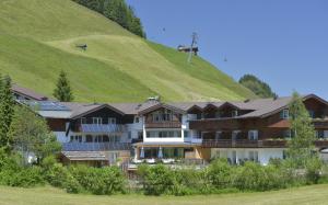 米特尔贝格拉岑霍夫自然酒店的一座以绿色山丘为背景的酒店