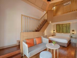 查汶苏梅岛阿玛瑞度假酒店的一间卧室配有一张床、一张沙发和一张桌子