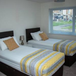 克劳利Crawley Apartment near Gatwick Manor Royal Newly Refurbished Sleeps 4的一间卧室设有两张床和窗户。