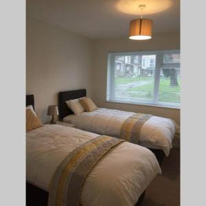 克劳利Crawley Apartment near Gatwick Manor Royal Newly Refurbished Sleeps 4的带窗户的客房内的两张床