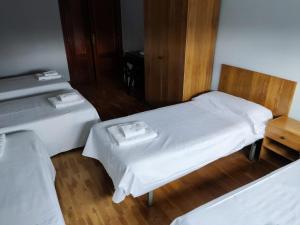 米兰达德埃布罗Pensión Las Matillas的客房设有两张带白色床单和桌子的床。