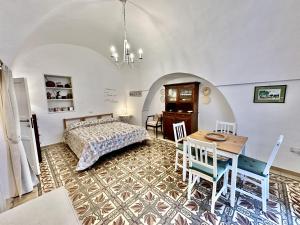 奥斯图尼Casetta Giorgia的卧室配有一张床和一张桌子及椅子