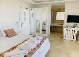 卡尔坎绿洲酒店 的白色卧室,配有带毛巾的床