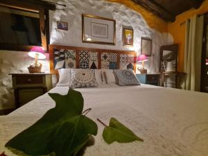 贝纳拉瓦Casa La Yedra by CasaTuristica的一间卧室配有一张大床,桌子上放着两盏灯