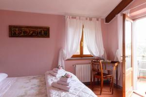 潘札诺罗索德尔基安蒂住宿加早餐旅馆的一间卧室配有一张床、一张书桌和一个窗户。