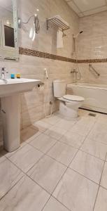吉达Golden New Hira Hotel的浴室配有盥洗盆、卫生间和浴缸。