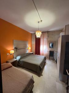 布林迪西阿普罗多酒店的酒店客房设有两张床和电视。