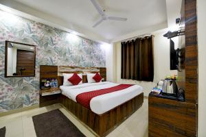 新德里Grand Empire Suites By Delhi Airport的酒店客房,配有床和电视