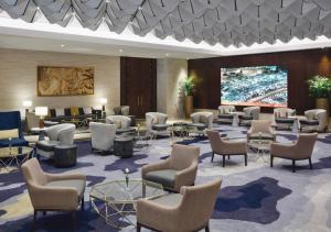 麦加麦加哈加塔瑞享酒店的大堂设有桌椅和投影屏幕