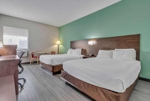 默特尔比奇Baymont by Wyndham North Myrtle Beach的酒店客房配有两张床和一张书桌
