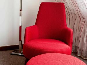 汉诺威Fora Hotel Hannover by Mercure的灯室里的红椅