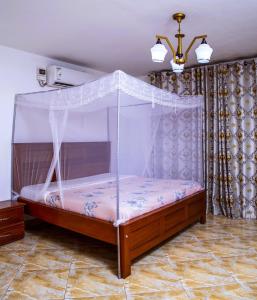 恩德培Hidden Treasure Serviced Hotel Apartments HITSHA HOTELS Entebbe的一张带天蓬的床