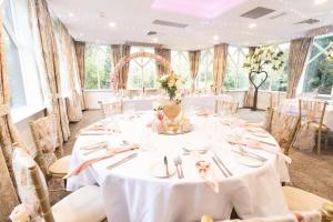 切斯特Crabwall Manor & Spa - BW Signature Collection的婚礼宴会厅配有白色的桌椅
