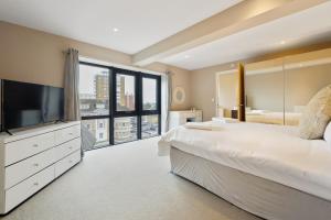 伯恩茅斯Westcliff Penthouse with Sea Views and Balcony的一间卧室配有一张大床和电视
