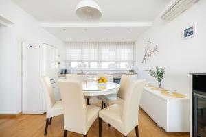 斯普利特Luxury residence Adriatic Pearl的白色的厨房配有白色的桌子和椅子