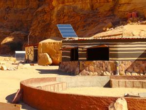 瓦迪拉姆Wadi rum view camp的顶部有太阳能电池板的房子