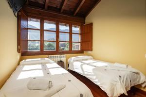 CuerresCasa ideal para familia en Ribadesella Africa的带窗户的客房内的两张床