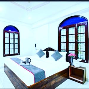 JojeraHotel Jheel Mahal New Town Inn West Bengal - Couple Friendly的一间卧室配有一张带水槽和窗户的床
