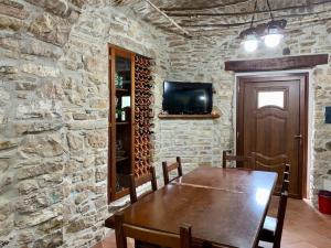 Il Casale - tra Passato e Modernità的一间设有木桌和石墙的用餐室