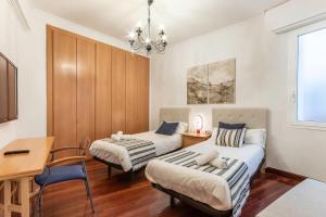 毕尔巴鄂San Mames Apartment - Free Parking的一间卧室配有两张床、一张桌子和一张桌子