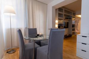 罗马Attic with Terrace and Jacuzzi - Luxury Apartment的一间设有玻璃桌和椅子的用餐室