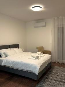 巴尼亚科维利亚查Vila Drina Apartments的一间卧室配有一张带白色床单的大床