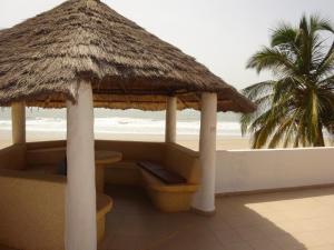 KabrousseHOTEL DU BAR DE LA MER CAP SKIRRiNG的海滩上的小屋,棕榈树