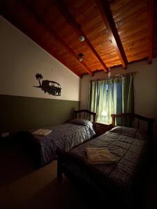 吉亚迪诺镇Don Hugo的一间卧室设有两张床和窗户。