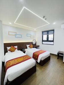 归仁Gia Kiên Hotel的酒店客房设有两张床和窗户。