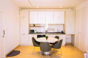 阿克拉The Pavilion 1BDR Luxury Apt的厨房配有白色橱柜和桌椅