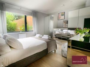 Bourne EndWooburn Green - Modern One Bedroom Apartment的一间带大床的卧室和一间客厅