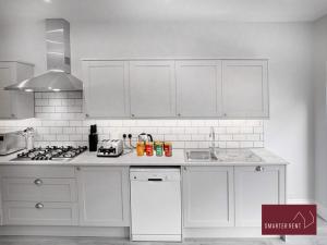 泰晤士迪顿Thames Ditton - Luxury 4 Bedroom House - Garden and Parking的厨房配有白色橱柜和炉灶烤箱。
