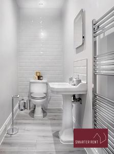 泰晤士迪顿Thames Ditton - Luxury 4 Bedroom House - Garden and Parking的白色的浴室设有水槽和卫生间。
