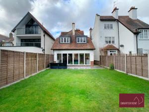 泰晤士迪顿Thames Ditton - Luxury 4 Bedroom House - Garden and Parking的一座带围栏和绿色庭院的房子