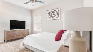 本顿维尔Landing Modern Apartment with Amazing Amenities (ID7008X25)的一间卧室配有一张床和一台平面电视