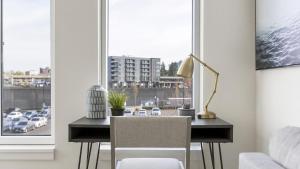 温哥华Landing Modern Apartment with Amazing Amenities (ID8566X33)的窗前带台灯和椅子的桌子