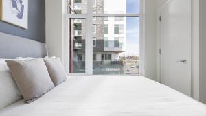 温哥华Landing Modern Apartment with Amazing Amenities (ID8566X33)的卧室配有一张大白色床和窗户
